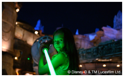 Girl holding a green lightsaber