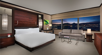 Image shows studio with king bed and two seated couch