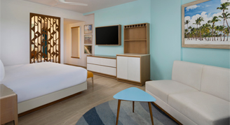 Photo of hotel room facing a king-sized bed and sofa.