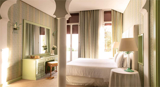 Image of a single bed leading to a balcony in a Premium Grand Deluxe Room.