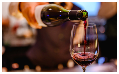 Image of a serving pouring wine into a tasting glass.