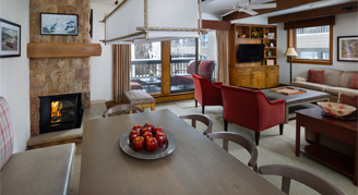 Photo of hotel room living space with dining table, fireplace, and balcony.