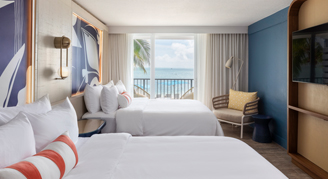 A room with a view, two beds, and a balcony.