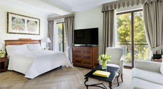 Premium Club room featuring King bed, television, and lounge area. 