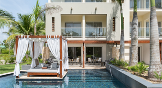 Image of an outdoor bed, in a pool in front of a suite.