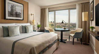 Photo of hotel room with one king bed and large windows.