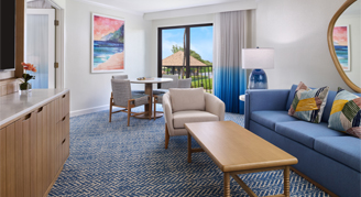 A view of the living area with sofa bed, coffee table and arm chair.