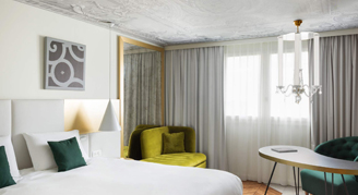 A view of a Superior Room with one queen bed and a chandelier.