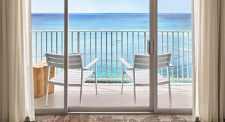 Image of the balcony overlooking the ocean in a Premier Oceanfront Room.