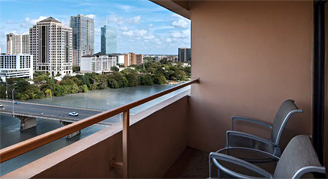 Image of a seating area on a balcony overlooking the city in a Lake-View Balcony Room.
