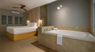 Photo of hotel room with a bed and large bathtub.