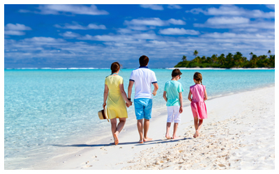 Family of four walking down the beach in Aitutaki in the Cook Islands