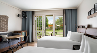 A room with a patio view including two queen beds and couch.