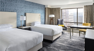 Image of two beds in a High-Floor Room leading to a window.