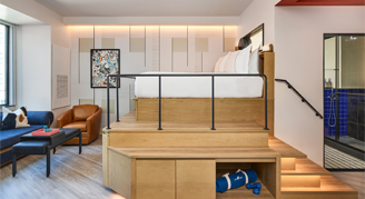 Photo of hotel room with elevated bed and living area.