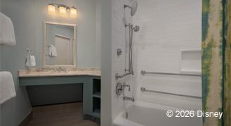 A mobility accessible bathroom featuring a tub and Vanity sink, mirror and lights.