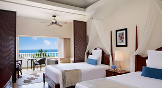 Two double beds with a balcony beachfront view of the ocean.