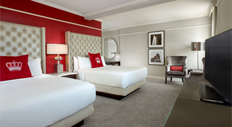 A view of two beds , a T.V., and a reading spot.