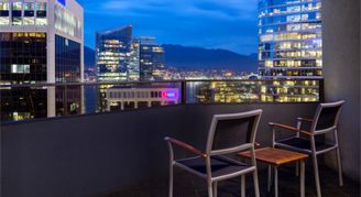Image of seating area on balcony overlooking the city.