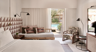 The bedding area leading out the sliding glass doors to the swim-up pool area.