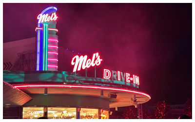 Exterior photo of the Mel's Diner sign at night.