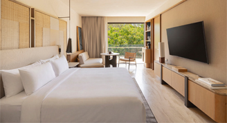 Image of a single bed leading to a balcony in a Beach Area Room.