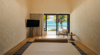 Image of a single bed leading to a balcony in an Ocean-View Signature Studio with Plunge Pool.