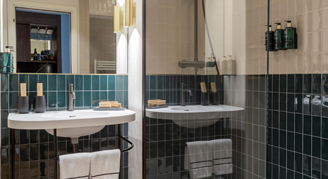 The sink and shower area with a mirror reflecting into the room behind.