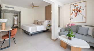 Image of a single bed in a hotel room with adjacent living room.