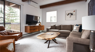 Photo of hotel room living space with large couch and balcony.