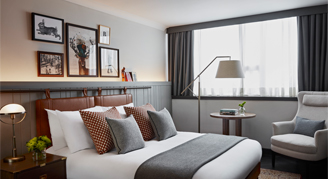 Roo with double bed and arm chair and small table