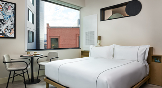 Interior view of the Flat Studio with a roll-in shower featuring a king bed.