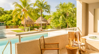 The image shows a swim-up terrace suite with a hot tub and direct pool access.