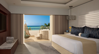 Presidential suite with a king bed and balcony view of the ocean.