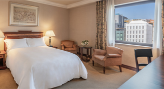 Cosy room featuring double bed, chair, and desk area
