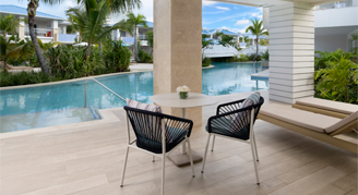 Photo of a hotel patio with seating area and walk-out to a pool.