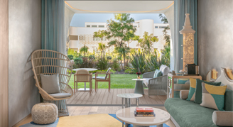 Image shows bright contemporary coastal decor and a private patio overlooking the garden.