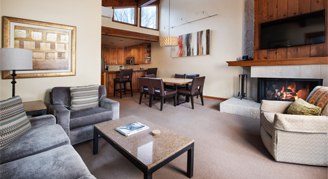 Photo of hotel living space with fireplace and dining table.