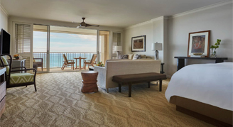 Photo of hotel suite with bed, sitting area and balcony.
