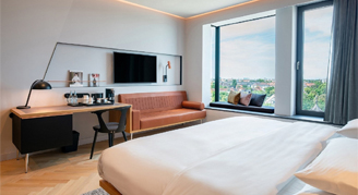 Image of the bedding, sitting area and window of the Tower Room.