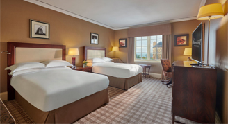 Image of the Deluxe Sea-View Room with two beds and adjacent window.