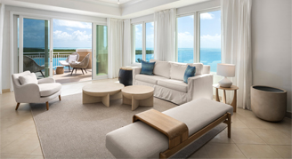 Photo of hotel suite living area and balconies with ocean views.