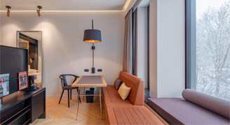 Image of the seating areas in the Deluxe Room at Andaz Munich Schwabinger Tor by Hyatt.