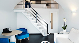 Clean white hotel room, staircase to bedroom.