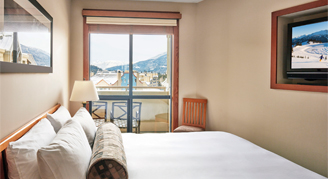 A bed with a lamp and a Sliding doors with a view outside the balcony