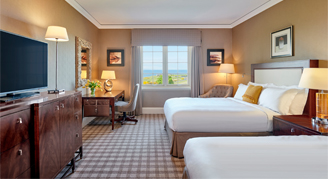 Image of the Fairmont-View Room with two beds, work desk and adjacent window.