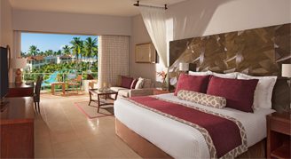 Image of a single bed leading to a patio overlooking the resort.