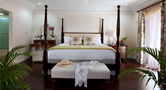 Photo of hotel room with a king-sized, four-poster bed.