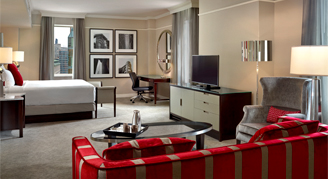 A view of the seating area with the bed in the background of the Premier Room.