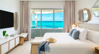 View of a King bed and window overlooking the water of the Three-Bedroom Beachfront Penthouse Suite with Skypool.